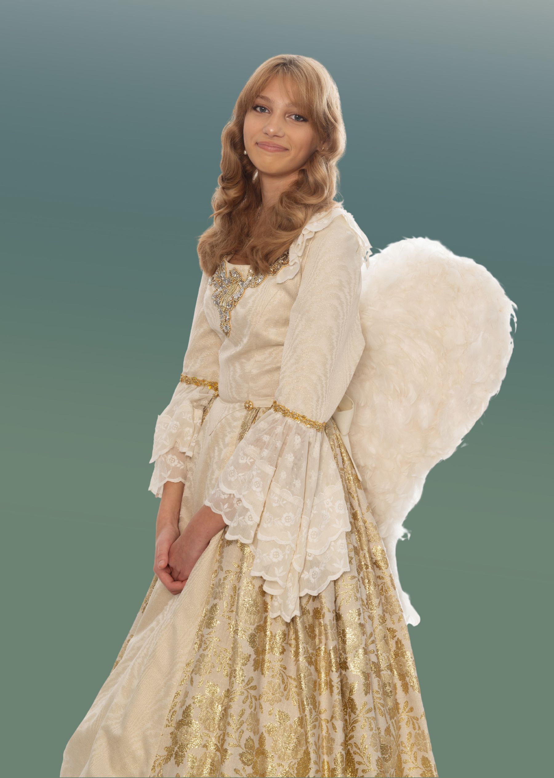 Eine junge Frau in einem verzierten weiß-goldenen Kleid mit Glockenärmeln und einem goldenen Gürtel, die gefiederte weiße Engelsflügel trägt, steht vor einem grünen Hintergrund mit Farbverlauf und lächelt sanft.