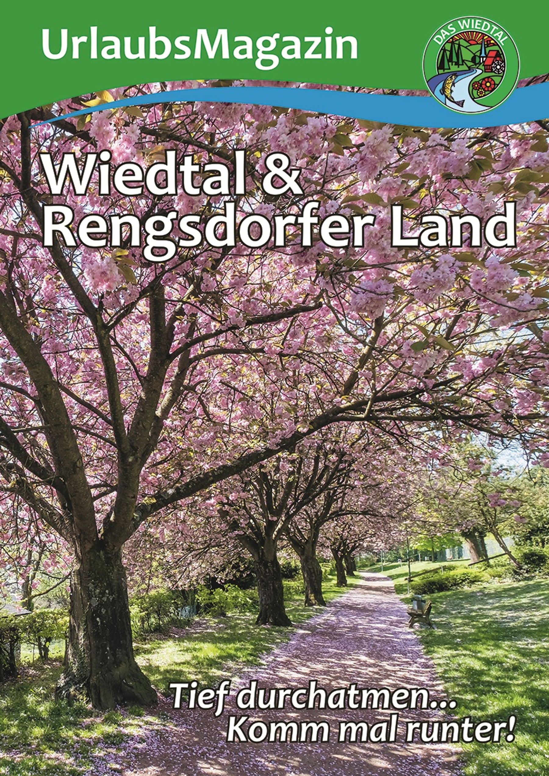 Cover of a travel magazine showing a path lined with pink blossoming cherry trees under a blue sky, with sunlight filtering through. The text reads: “UrlaubsMagazin Wiedtal & Rengsdorfer Land. Tief durchatmen… Komm mal runter!”.